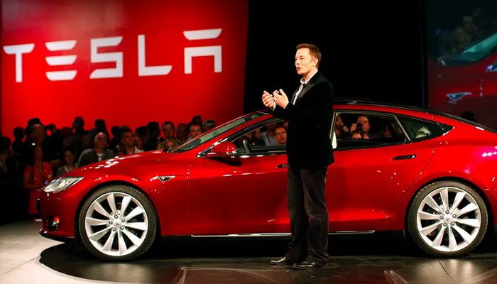 An undated image showing Elon Musk standing Tesla car. — Reuters