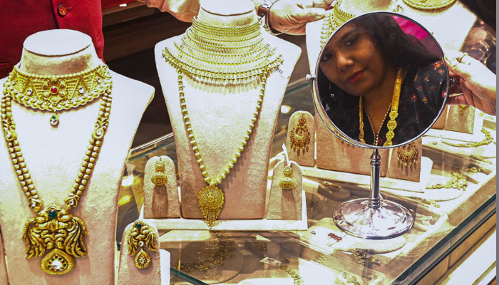 An undated image of a customer trying gold jewellery. — AFP