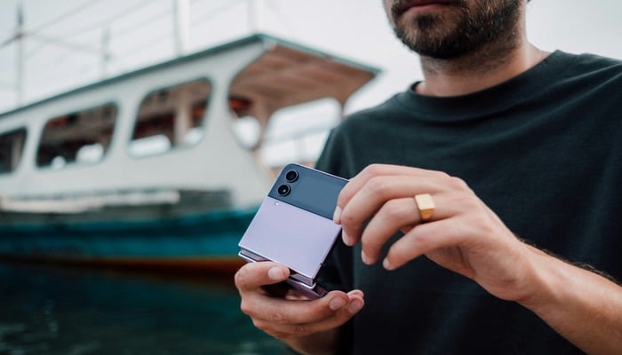 An undated image of a person using a fold android phone. — Unsplash