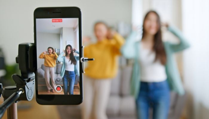 An undated image of 2 girls using the TikTok app. — Canva