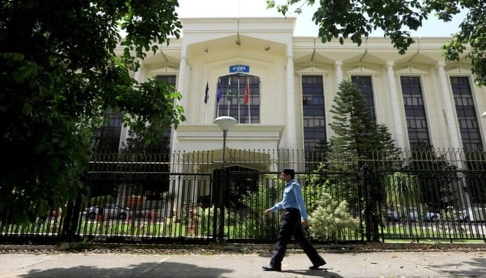 An image of a policeman walking past the Federal Board of Revenue (FBR) office building in Islamabad, August 29, 2018. — Reuters