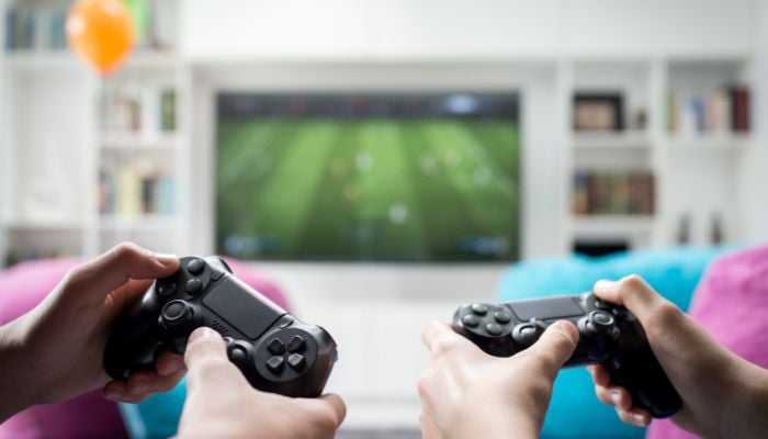 An undated image of two people using gaming consoles to play games. — Canva