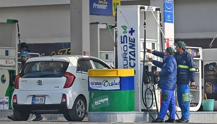Employees at a fuel station attend to their customers in Islamabad on February 16, 2022. — AFP