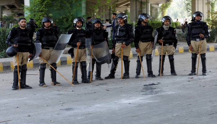 Police officer in riot gear stand guard outside a Radio Pakistan office building after it was set afire by the supporters of Pakistans former Prime Minister Imran Khan during a protest against his arrest, in Peshawar, Pakistan, May 11, 2023. — Reuters
