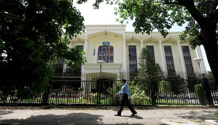 A policeman walks past the Federal Board of Revenue (FBR) office building in Islamabad, August 29, 2018. — Reuters