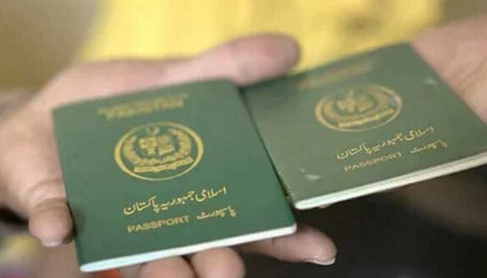 An undated image of two persons holding Pakistani passports. — AFP