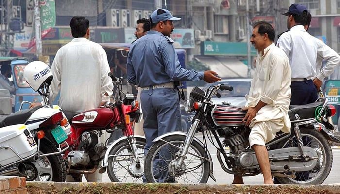 An undated image shows a traffic police official interacting with a citizen. — Traffic Police Punjab website