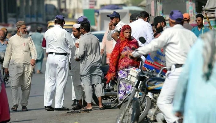 Traffic police officials issue a challan for violating the traffic rules in Karachi on April 15, 2025. — PPI