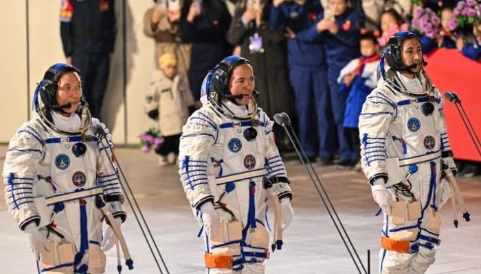 An image of astronauts for Chinas Shenzhou-21 space mission, Zhang Hongzhang (L), Commander Zhang Lu (C) and Wu Fei (R), wave during a departure ceremony before boarding a bus to take them to the Shenzhou-21 spaceship at the Jiuquan Satellite Launch Centre in the Gobi Desert in northwest China on October 31, 2025. — AFP
