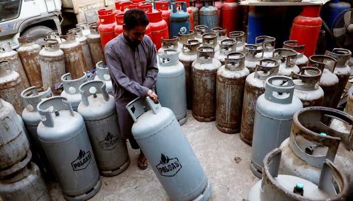 A worker moves a liquid petroleum gas (LPG) cylinder at a workshop in Karachi, Pakistan September 17, 2018. — Reuters