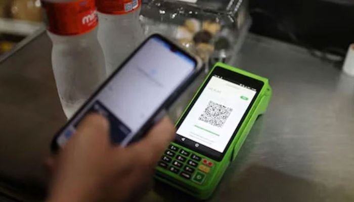 An image of person paying using their cell phone with instant electronic payment mode at store on April 1, 2024. — Reuters
