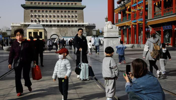 People walk at a tourism site in Qianmen Street, Beijing, China, March 14, 2023. — Reuters
