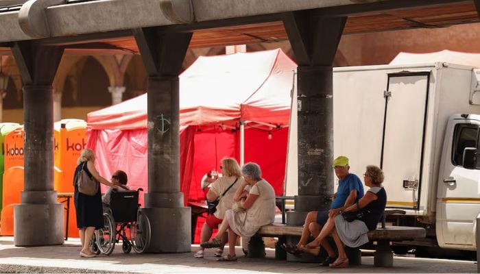 An image of elderly people taking shelter from the sun at a bus station in Forli, Italy, July 19, 2023. — Reuters