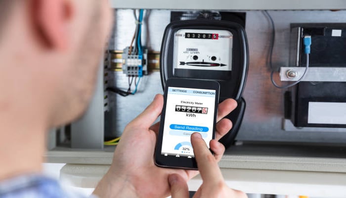 An undated image of person doing meter reading with smartphone. — iStock