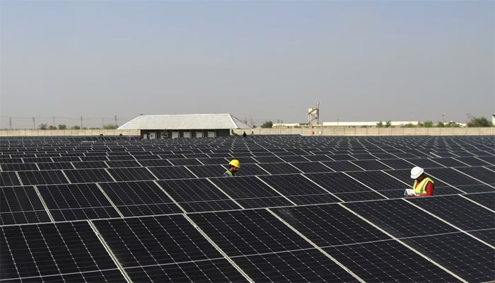 Technicians walk between solar panels at Interloop industrial park, in Faisalabad, Pakistan April 8, 2025. — Reuters