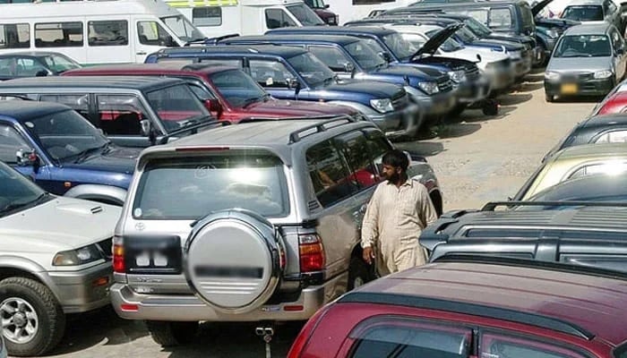 An undated image shows person seen walking alongside parked cars. — AFP