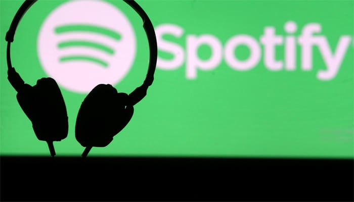 Headset is seen in front of a screen projection of Spotify logo, in this picture illustration taken April 1, 2018. — Reuters