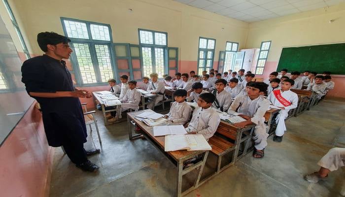 Ibrar Ahmad, (R - 2nd row) who survived after being rescued from a stranded cable car, sits with other children in a classroom at a school in Battagram, Pakistan, August 23, 2023. — Reuters