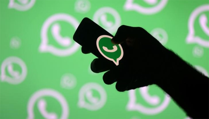 A man poses with smartphone in front of displayed WhatsApp logo in this illustration September 14, 2017. — Reuters
