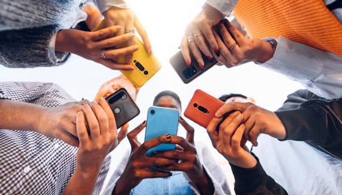 An undated image shows people using smartphones. — iStock