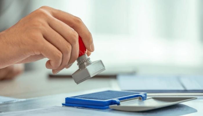 An undated image of a person stamping a document. — Shutterstock