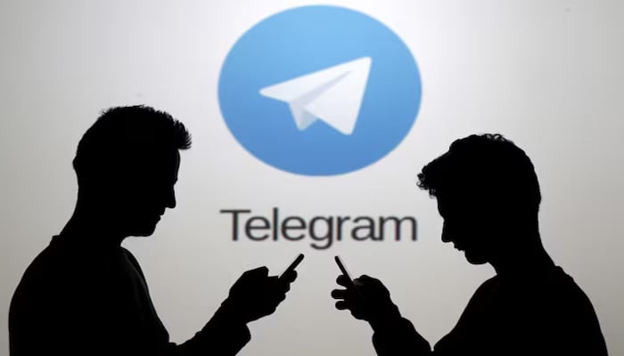 Two men pose with smartphones in front of a screen showing the Telegram logo in this picture illustration taken in Zenica, Bosnia and Herzegovina November 18, 2015. — Reuters