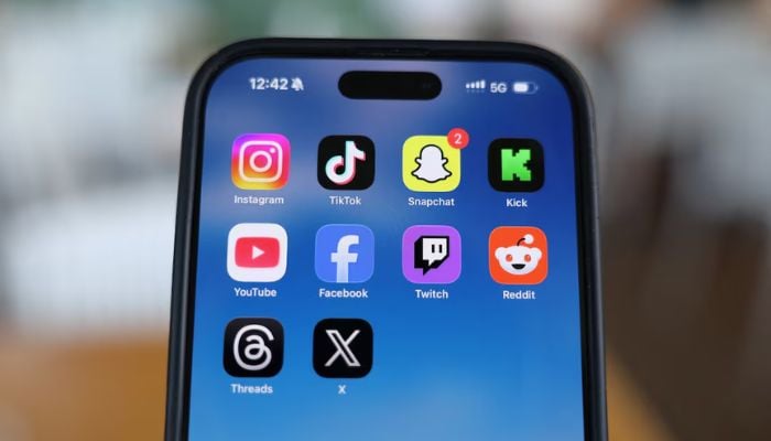 An image of Instagram, TikTok, Snapchat, Kick, YouTube, Facebook, Twitch, Reddit, Threads and X applications displayed on a mobile phone in this picture illustration taken on December 9, 2025. — Reuters