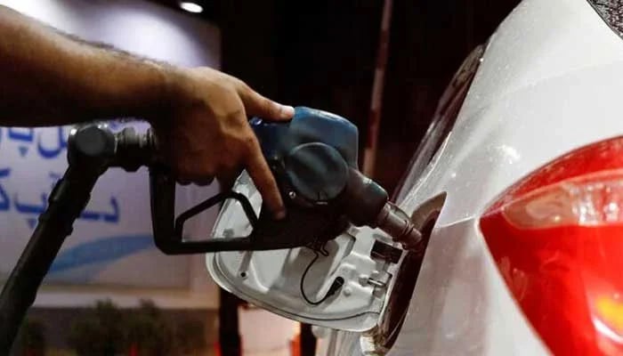 A worker holds a fuel nozzle to fills fuel in a car, after the government announced the increase of petrol and diesel prices, at petrol station in Karachi. — Reuters