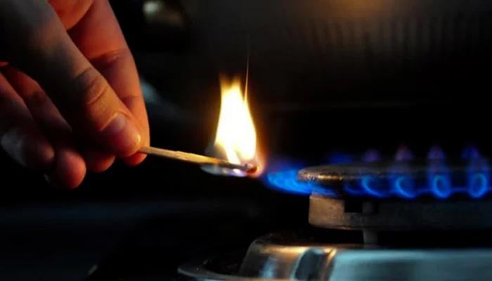 An undated image of a person lighting a stove. — AFP