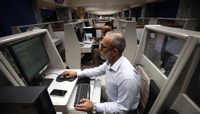 A stockbroker monitors share prices on computers during a trading session at the Pakistan Stock Exchange (PSX) in Karachi on October 2, 2025. — EPA