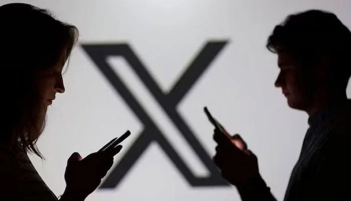 Teenagers pose for a photo while holding smartphones in front of a X logo in this illustration taken September 11, 2025. — Reuters