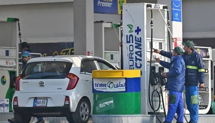 Employees at a fuel station attend to their customers in Islamabad, Pakistan. — AFP/File