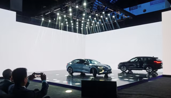 An attendee takes photos of Chinese EV BYD models on display, during event to announce plans to open car production plant in Pakistan, in Lahore, Pakistan August 17, 2024. — Reuters