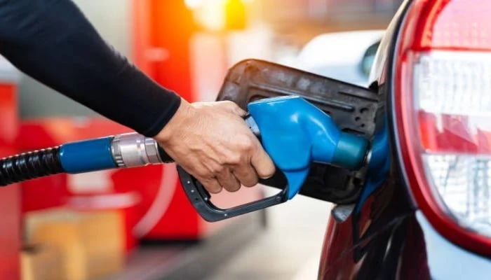 An undated image shows a person refilling his cars tank with fuel. — iStock
