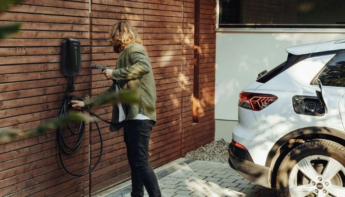 An undated image of a man using EV charger. — Unsplash