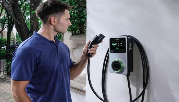 An undated image of a man holding an EV charger.