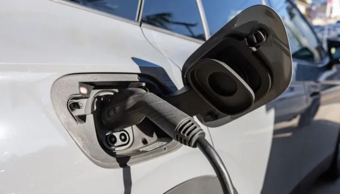 An undated image of a car connected to an EV charger.