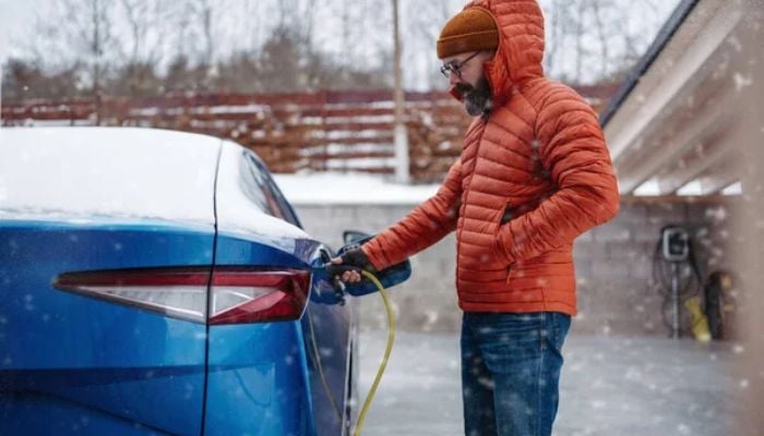 An undated image of a man using EV charger. — DepositPhotos